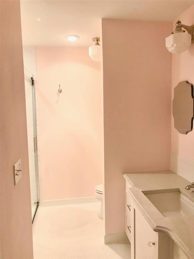 bathroom with vanity, toilet, and a shower