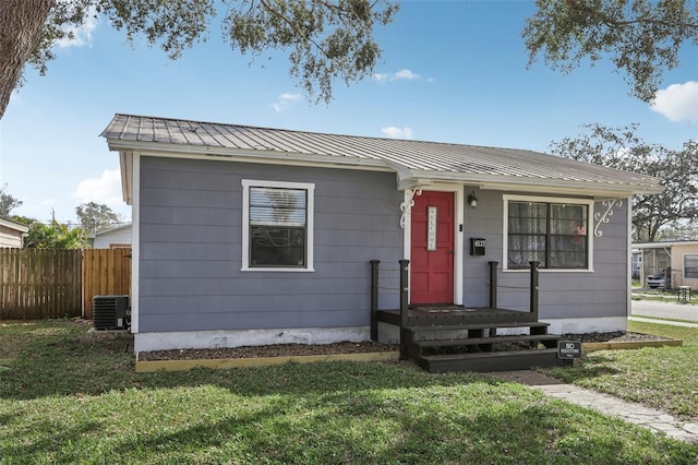 view of front of property with a front lawn and central air condition unit