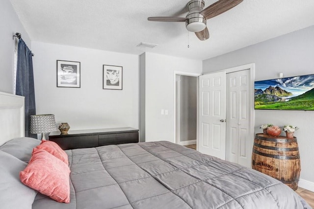 bedroom with visible vents, baseboards, a ceiling fan, a closet, and light wood finished floors