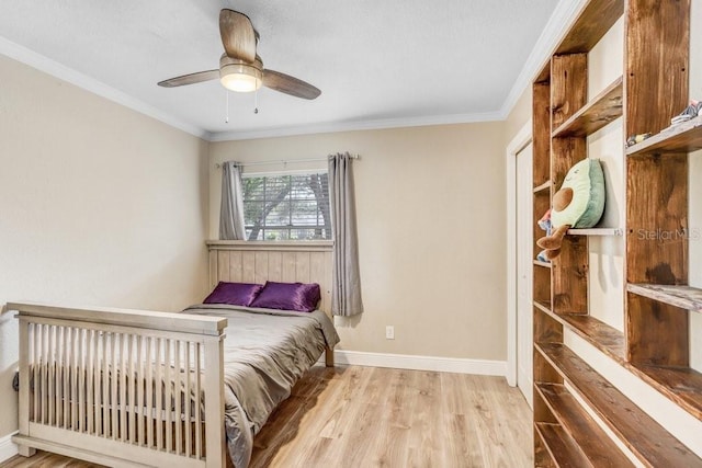 bedroom featuring light wood-style floors, ornamental molding, baseboards, and a ceiling fan