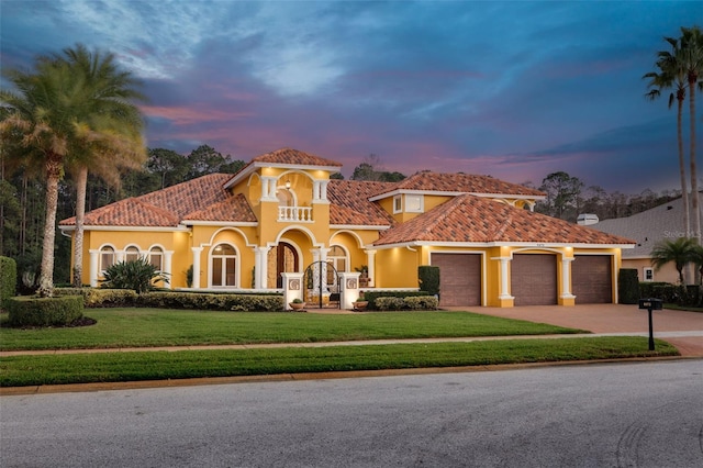 mediterranean / spanish house with a garage and a lawn