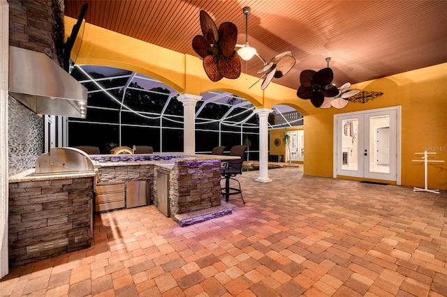 view of patio featuring french doors, ceiling fan, a lanai, and exterior kitchen