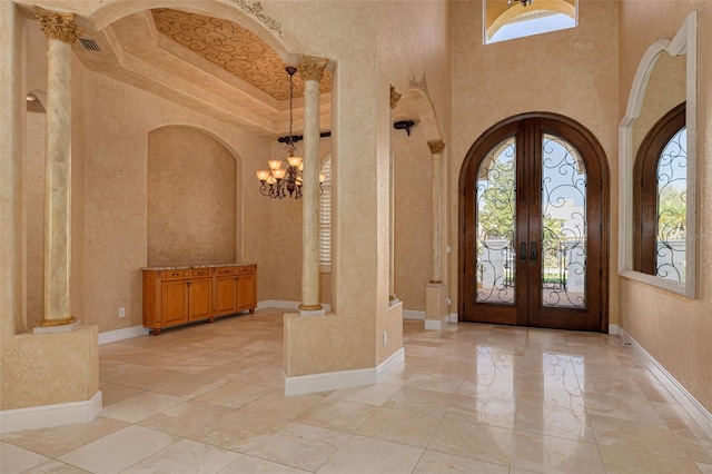 entryway with a towering ceiling, plenty of natural light, and french doors