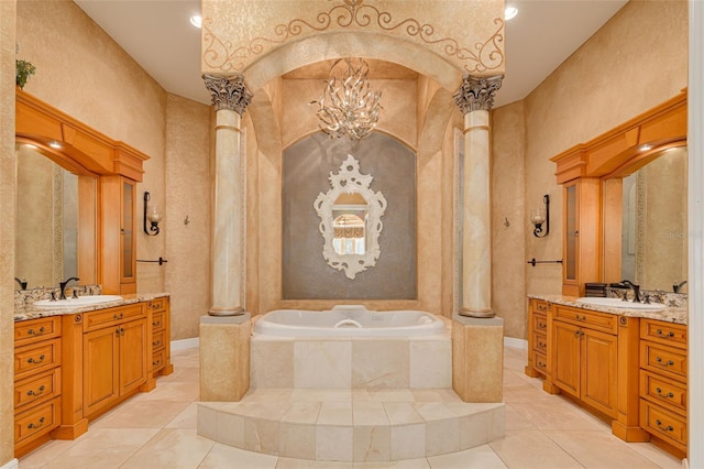 bathroom with vanity, tiled bath, and ornate columns