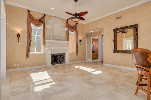 unfurnished living room featuring ceiling fan, ornamental molding, and a healthy amount of sunlight