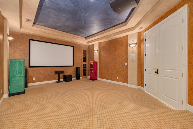 cinema with carpet flooring and a raised ceiling