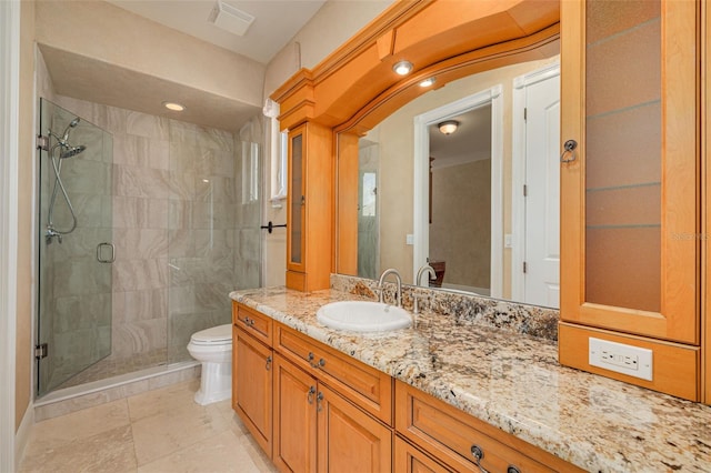 bathroom with a shower with door, vanity, and toilet