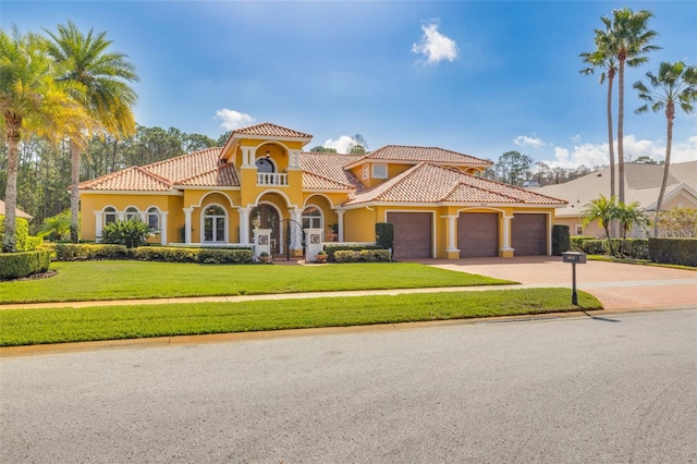 mediterranean / spanish house featuring a garage and a front lawn