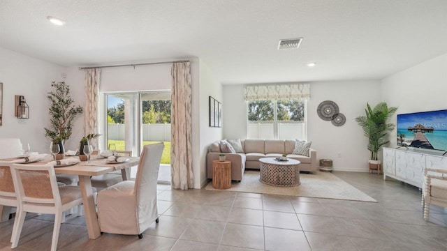 tiled dining space with plenty of natural light and a textured ceiling