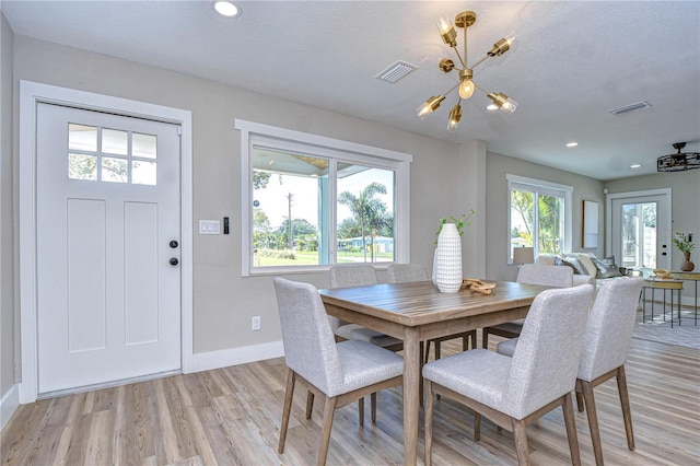 dining room with a textured ceiling and light wood-type flooring