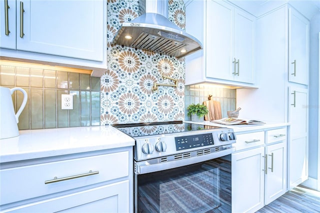 kitchen featuring white cabinets, stainless steel range with electric stovetop, island range hood, and backsplash