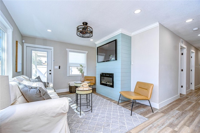 living room with light hardwood / wood-style floors, a large fireplace, and a textured ceiling