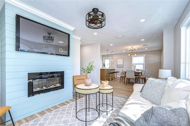 living room featuring a large fireplace, a textured ceiling, and light wood-type flooring