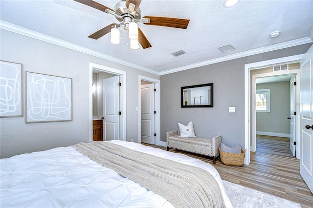 bedroom featuring crown molding, light hardwood / wood-style floors, and a textured ceiling