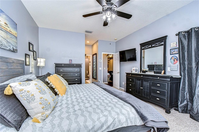 carpeted bedroom with ceiling fan, a closet, and a textured ceiling