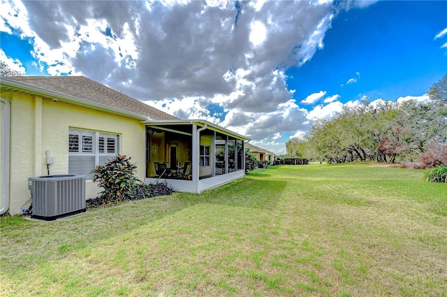 view of yard featuring cooling unit, a garage, and a sunroom