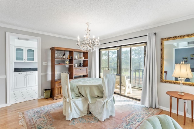 dining room featuring a chandelier, light wood-type flooring, crown molding, and a textured ceiling