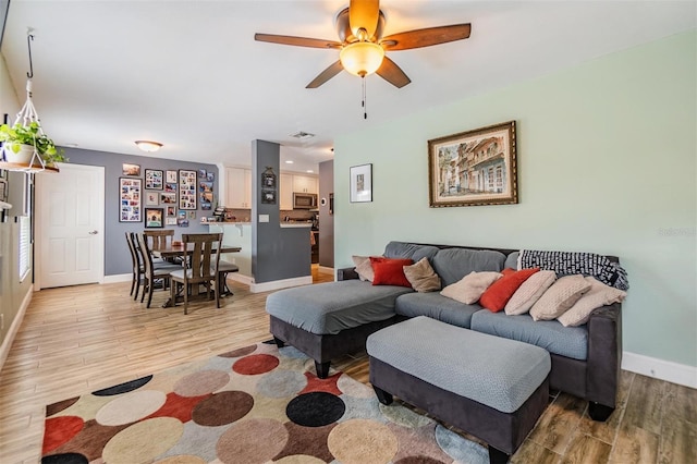 living room featuring ceiling fan and light wood-type flooring