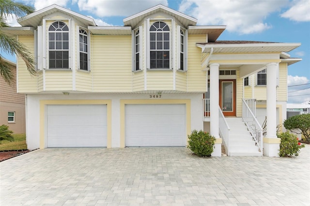 view of front facade featuring a garage, decorative driveway, and stucco siding