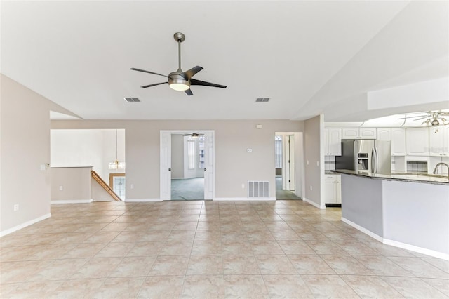 unfurnished living room featuring visible vents and a ceiling fan