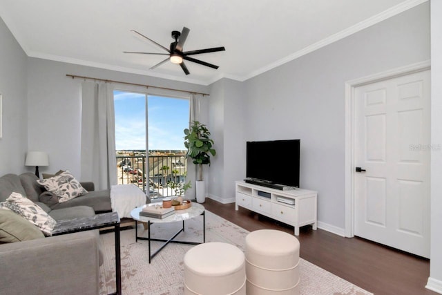 living area with baseboards, wood finished floors, a ceiling fan, and crown molding