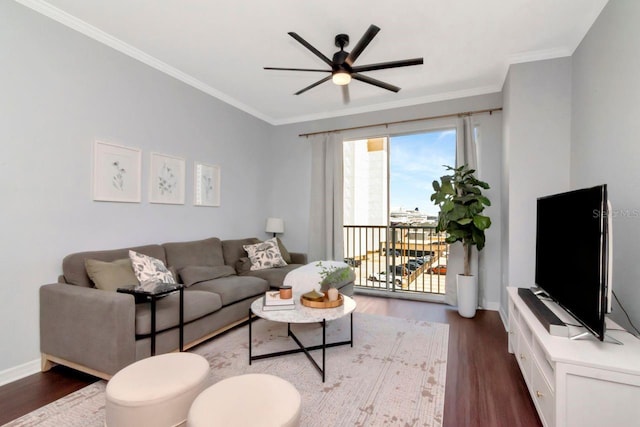 living room featuring baseboards, dark wood-type flooring, a ceiling fan, and crown molding