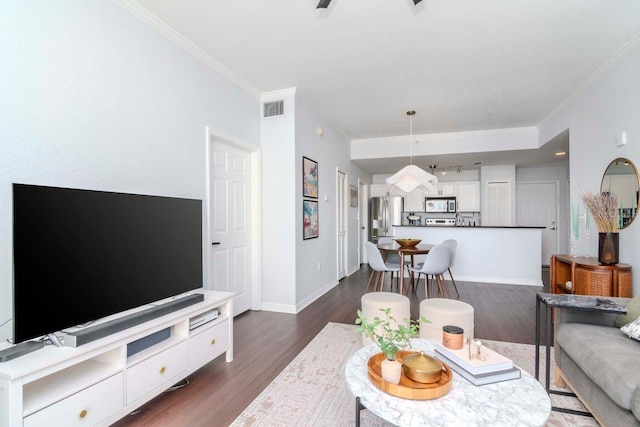 living room featuring dark wood-style floors, visible vents, crown molding, and baseboards