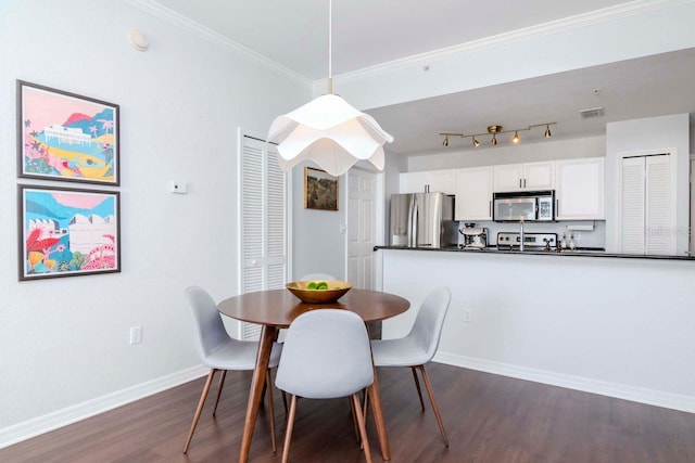 dining space with dark wood-type flooring, visible vents, baseboards, ornamental molding, and track lighting