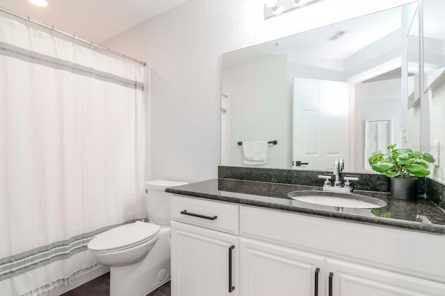 bathroom featuring toilet, a shower with curtain, visible vents, and vanity