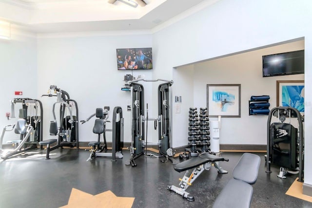 exercise room with baseboards and ornamental molding