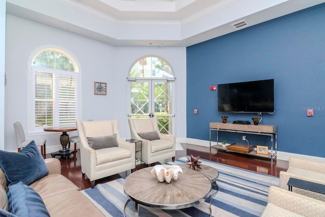 living area featuring ornamental molding, a raised ceiling, visible vents, and baseboards