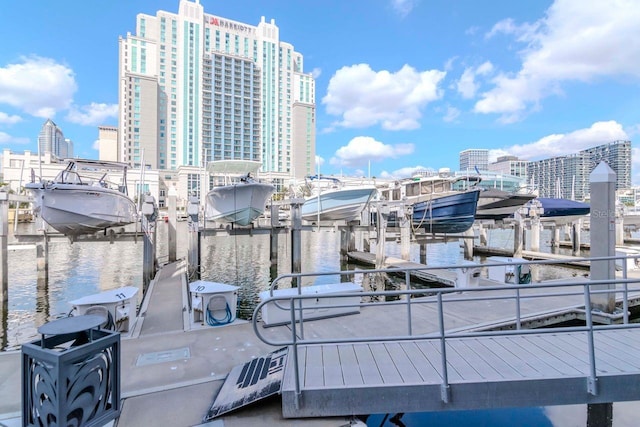 view of dock featuring a water view, boat lift, and a city view