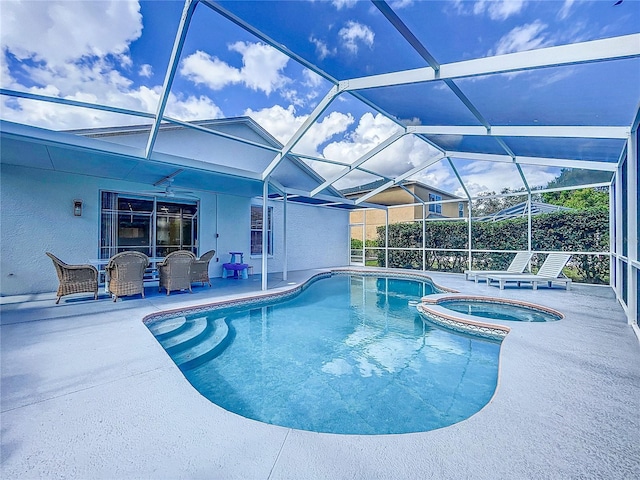 view of pool featuring an in ground hot tub, glass enclosure, and a patio area