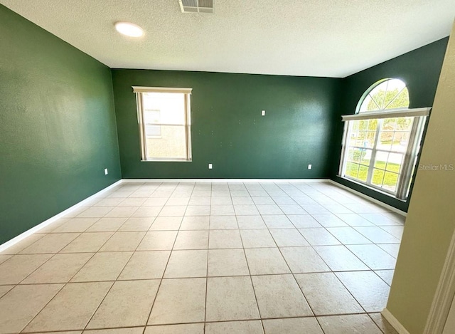 1609 Shady Oaks Dr, Oldsmar, FL 34677 - empty room featuring a textured ceiling, light tile patterned floors, baseboards, and an accent wall