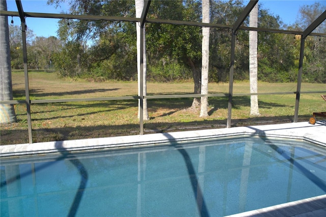 view of pool with a lanai and a lawn