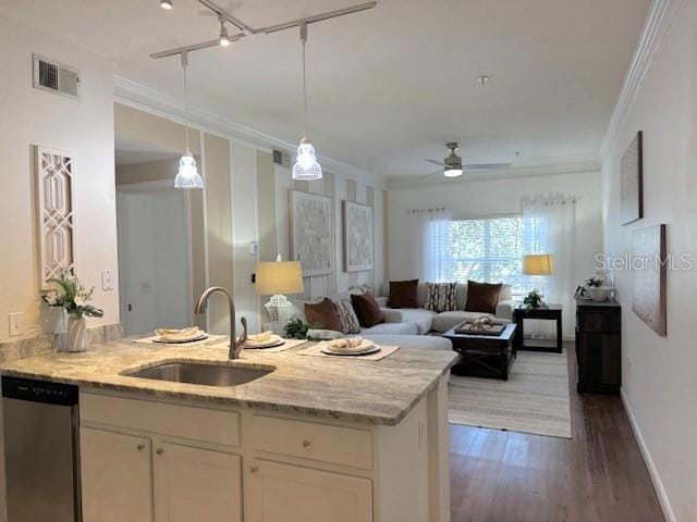 kitchen featuring pendant lighting, white cabinetry, dishwasher, sink, and light stone countertops