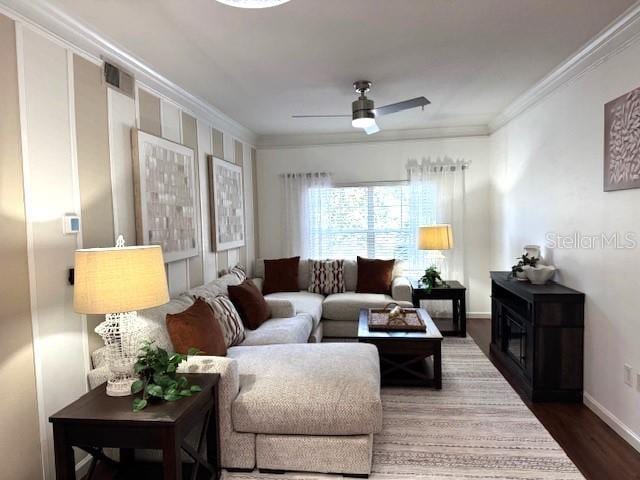 living room with crown molding, dark hardwood / wood-style floors, and ceiling fan