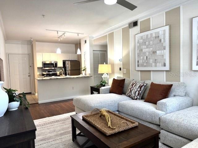 living room featuring crown molding, ceiling fan, track lighting, and hardwood / wood-style floors