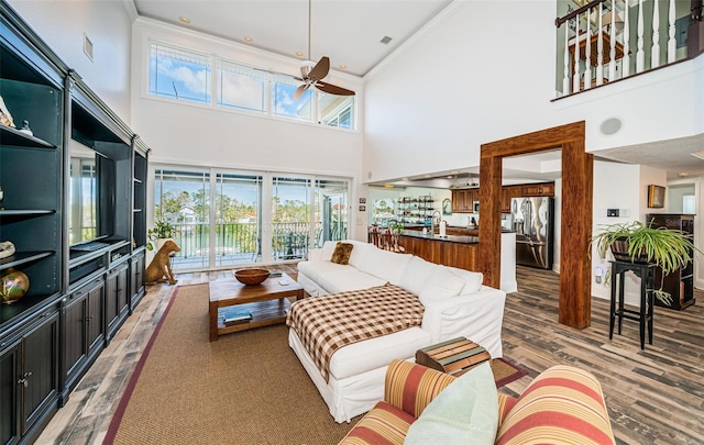 living area featuring visible vents, ornamental molding, wood finished floors, and a ceiling fan