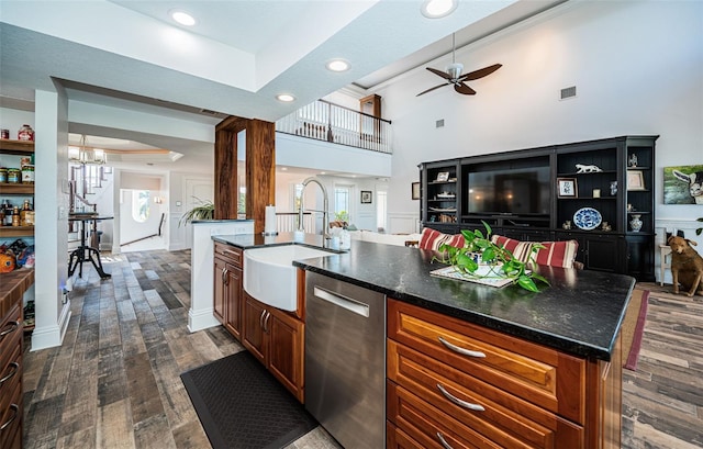 kitchen with visible vents, stainless steel dishwasher, dark wood-type flooring, a kitchen island with sink, and a sink