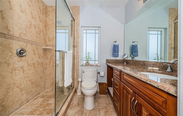 bathroom with a tile shower, vanity, and toilet