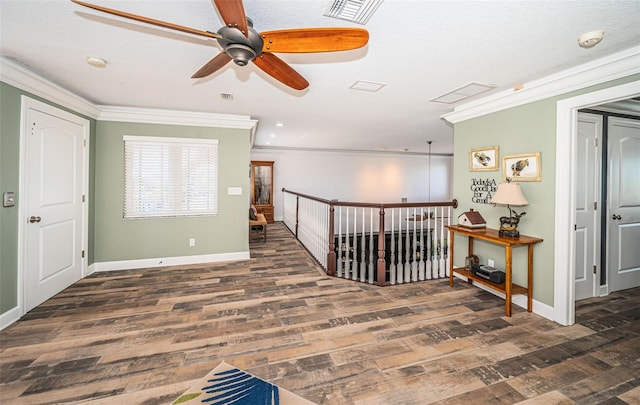 unfurnished room with ornamental molding, visible vents, baseboards, and dark wood-style floors