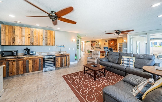 living room featuring wine cooler, light tile patterned floors, recessed lighting, a ceiling fan, and a textured ceiling