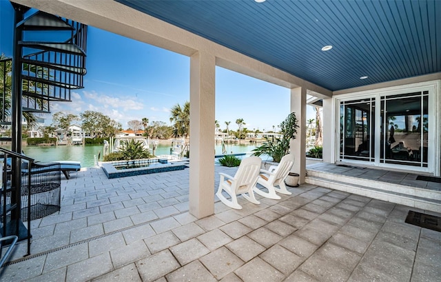 view of patio featuring a water view and stairs