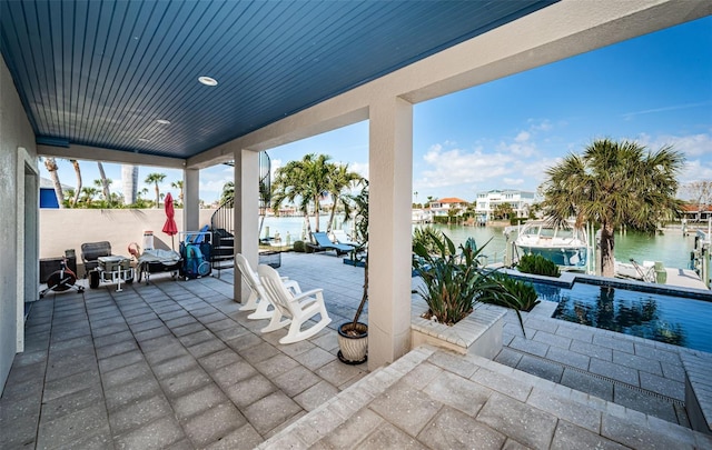 view of patio with a boat dock, a water view, and fence