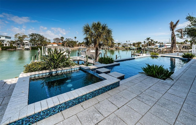 view of pool featuring a boat dock, a water view, and a pool with connected hot tub