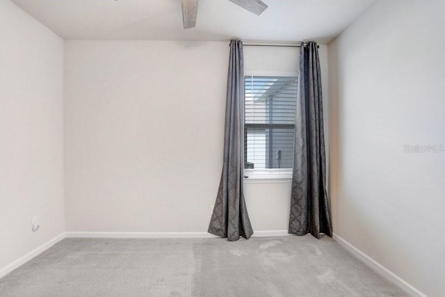 carpeted spare room featuring ceiling fan