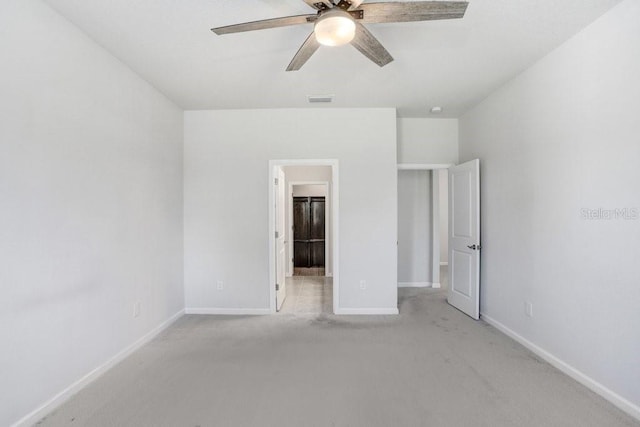 unfurnished bedroom featuring ceiling fan, ensuite bathroom, and light carpet