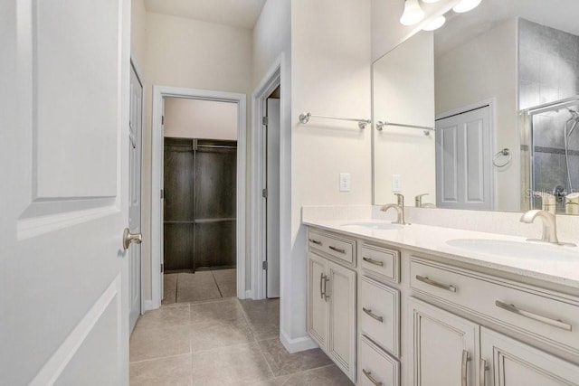 bathroom featuring a shower with door, vanity, and tile patterned flooring