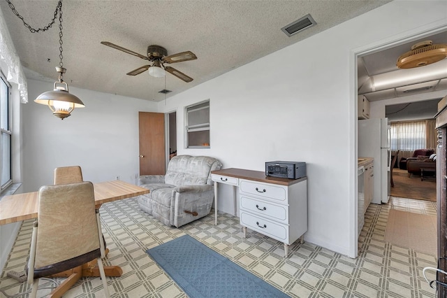 sitting room with a textured ceiling and ceiling fan